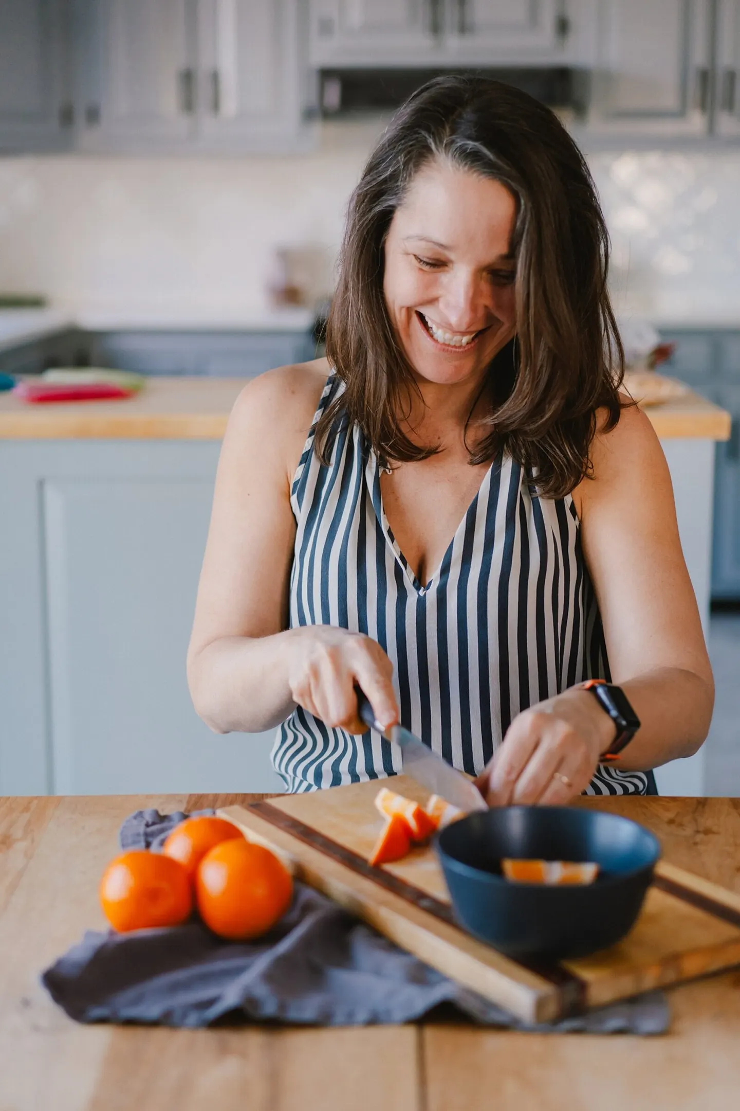 Young girl peers through two strawberry halves held up like binoculars, grinning