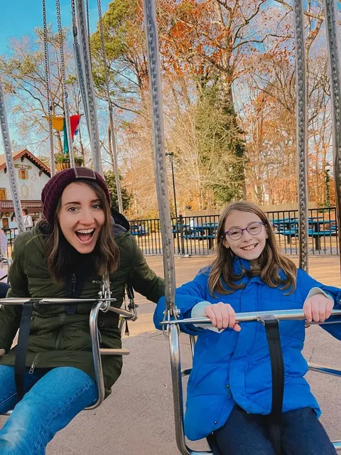 Leah O'Connell laughing with her daughter on a carnival swing ride