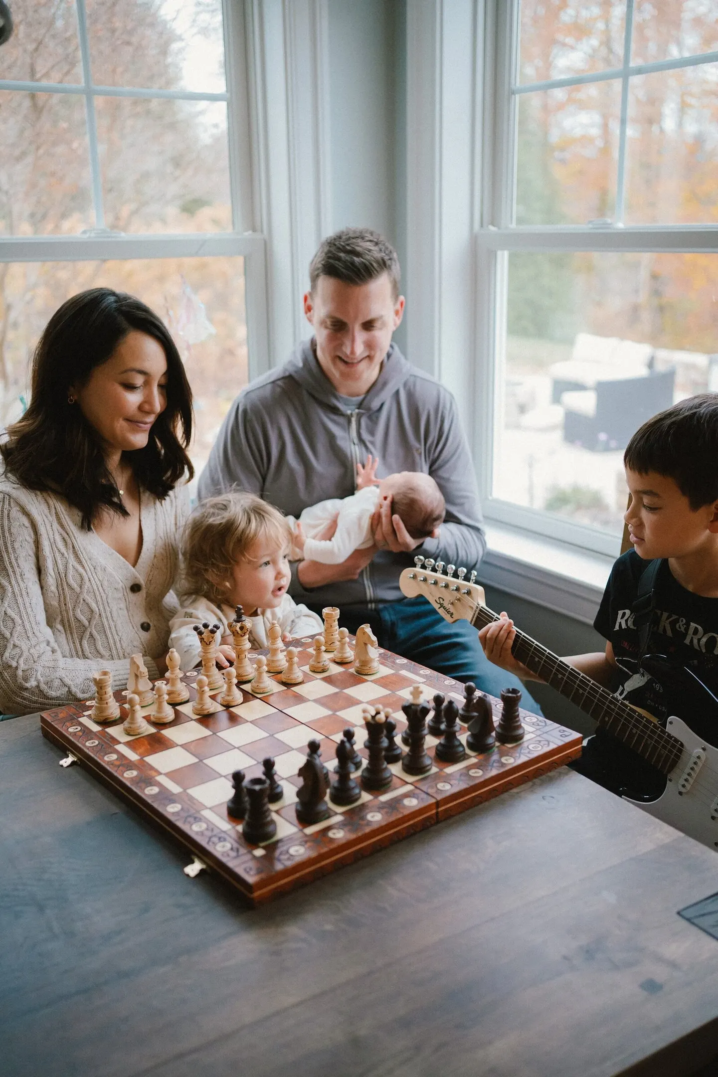 newborn photos in charlottesville around the kitchen table with 2 siblings