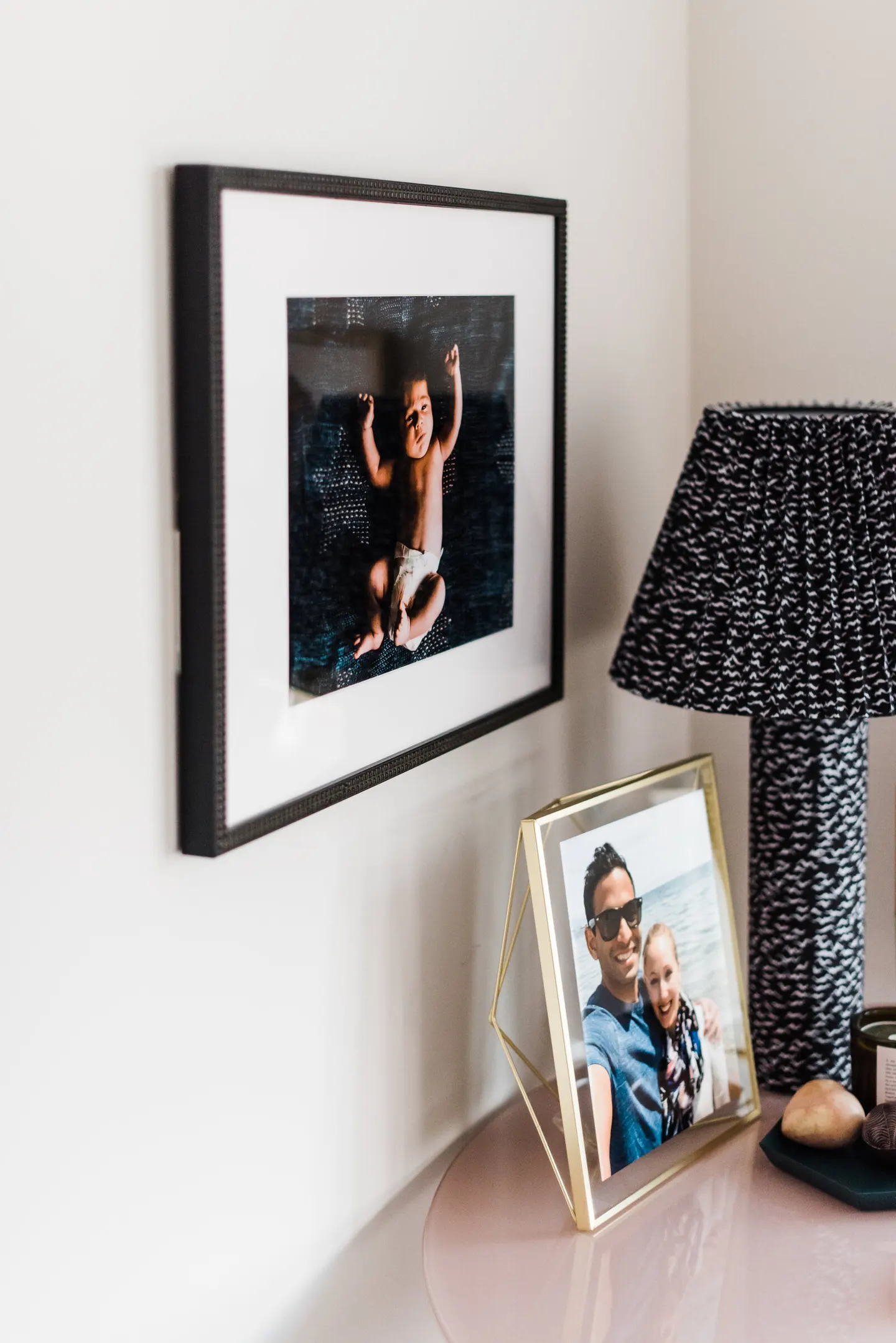 White-matted frame leaning against shiplap, two brothers laughing together on a porch bench