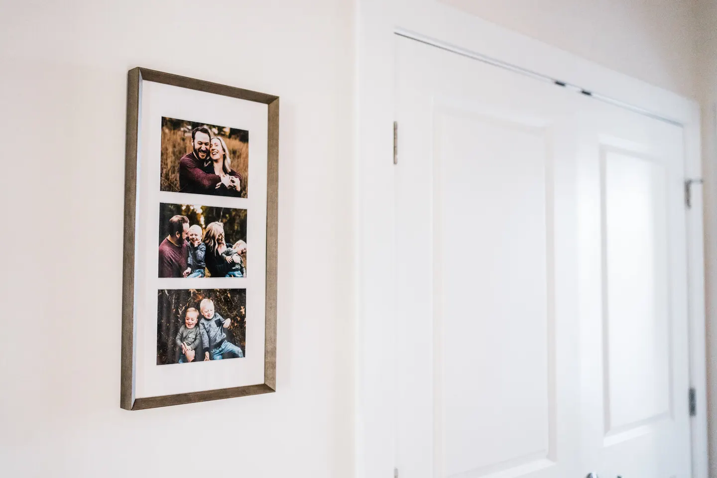 Slim gray triptych frame in a hallway, engagement and family portraits stacked in one mat